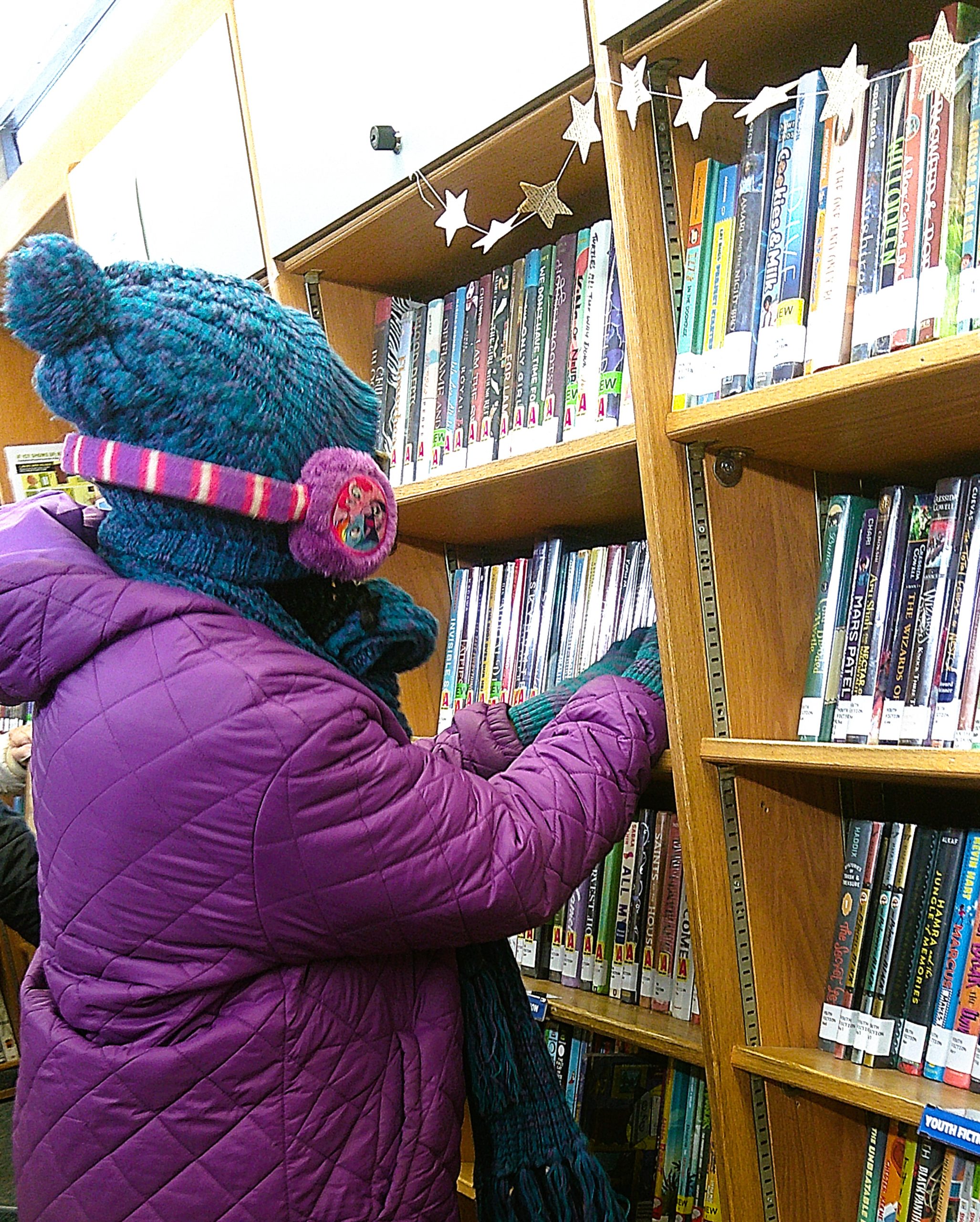 A Continuum participant selecting a book inside the YDL Bookmobile